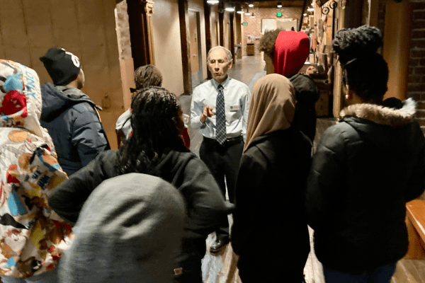 A docent leading a Museum group tour for middle school children.