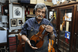 Amnon Weinstein holding one of his restored violins