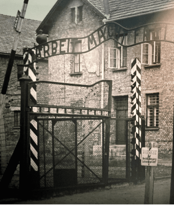 Black and white photo of sign aboce gates in Auschwitz