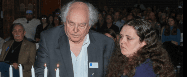 Dr. Rojer Loria and his daughter Rachel lighting the candles at Yom HaShoah 2024.