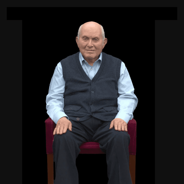 Holocaust survivor Pinchas Gutter sitting in a burgandy chair being filmed for his DIT interview